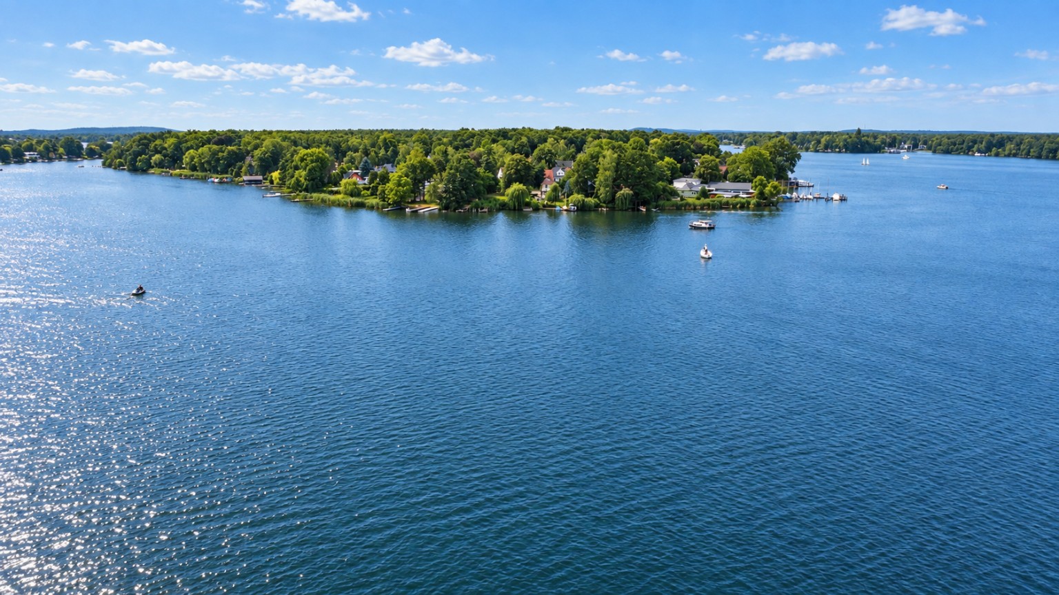 Luftaufnahme über den See mit bewaldetem Ufer